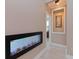 Hallway featuring a modern linear electric fireplace and neutral wall tones at 5011 Sandy Brook Cir, Wimauma, FL 33598