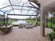 Large covered patio with seating, dining and lake view at 5011 Sandy Brook Cir, Wimauma, FL 33598