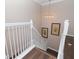 Modern white staircase with dark hardwood floors and neutral wall decor at 5011 Sandy Brook Cir, Wimauma, FL 33598