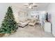 Spacious living room featuring a comfortable sectional sofa, a large TV, and a Christmas tree at 6307 Osprey Lake Cir, Riverview, FL 33578