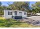 Front view of a white manufactured home with gray deck and landscaping at 6633 Dog Rose Dr, Wesley Chapel, FL 33544