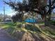 Light blue house nestled amongst large oak trees, showcasing a spacious yard at 6928 E 29Th Ave, Tampa, FL 33619