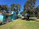 Side view of a light blue house with a large yard and mature trees at 6928 E 29Th Ave, Tampa, FL 33619