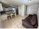Living room with tile floors, a sofa, and a kitchen view at 6928 E 29Th Ave, Tampa, FL 33619