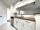 White kitchen cabinets and wood countertops at 8714 Mallard Reserve Dr # 104, Tampa, FL 33614