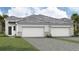 Two-car garage, two-story home with gray roof and light-colored siding at 11279 Boundless Ter, Venice, FL 34293