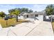 Front view of a single-story house with a driveway and a palm tree at 11513 Rampart Ln, Port Richey, FL 34668