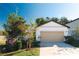 Cute one-story house with a beige garage door and landscaping at 11730 Adam Lee Way, Dade City, FL 33525