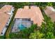 An aerial view of a home with a large, screened-in pool and spa at 16313 Heathrow Dr, Tampa, FL 33647