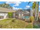 Backyard view with a pool, screen enclosure, and well-maintained lawn at 18308 Felspar Way, Tampa, FL 33647