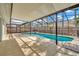 Covered patio with a screened-in pool, tiled flooring, and neutral walls at 18308 Felspar Way, Tampa, FL 33647