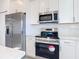 Modern kitchen with stainless steel appliances and white cabinets at 211 Australian Dr, Rotonda West, FL 33947