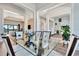 Bright dining room with glass table and seating for six, offering views into the living area at 323 Hawk Talon Dr, Lithia, FL 33547