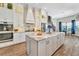 Open kitchen with white cabinets, marble island, and stainless steel appliances at 323 Hawk Talon Dr, Lithia, FL 33547