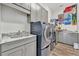 Laundry room with washer, dryer, and gray cabinets at 323 Hawk Talon Dr, Lithia, FL 33547