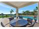 Relaxing patio with table and chairs overlooking the pool and tranquil waters at 323 Hawk Talon Dr, Lithia, FL 33547