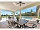 Spacious covered patio features dining area, pool and water views at 323 Hawk Talon Dr, Lithia, FL 33547