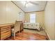 Well-lit bedroom with wood-look flooring, neutral walls, and dedicated desk space at 4635 Orange Blossom Dr, Zephyrhills, FL 33542