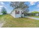 Charming single-story home with white siding, red shutters, and mature trees on a spacious lawn at 4635 Orange Blossom Dr, Zephyrhills, FL 33542