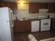 Efficient kitchen featuring wood cabinets and white appliances at 4635 Orange Blossom Dr, Zephyrhills, FL 33542