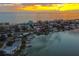 Aerial view of waterfront homes at sunset, showcasing canals and ocean at 498 Crystal Dr, Madeira Beach, FL 33708