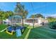 Spacious backyard with artificial turf, trampoline, and screened patio at 7100 14Th N St, St Petersburg, FL 33702