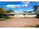 Single-story home with brick driveway, palm trees, and glass-block accent wall at 10244 Tarpon Dr, Treasure Island, FL 33706