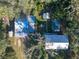 Aerial view showing a property with houses, sheds, and a pool, surrounded by trees at 11008 Browning Rd, Lithia, FL 33547