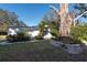 White shed with landscaping and a large tree at 11008 Browning Rd, Lithia, FL 33547