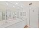 Bright bathroom with double sink vanity, large mirror, and glass enclosed shower stall at 1200 Country Club Dr # 3204, Largo, FL 33771