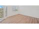 A bedroom with wood floors, a window, and a sliding glass door leading to a balcony at 1200 Country Club Dr # 3204, Largo, FL 33771