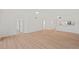 Open-concept living room featuring light-colored wood floors and white walls, flowing into kitchen area at 1200 Country Club Dr # 3204, Largo, FL 33771