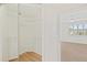 Walk-in closet with wire shelving and light-colored wood-look flooring adjacent to bright bedroom at 1200 Country Club Dr # 3204, Largo, FL 33771