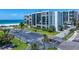 View of exterior beachfront condos with lush landscaping and a large parking lot at 1400 Gulf Blvd # 801, Clearwater Beach, FL 33767
