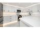 Modern white kitchen with stainless steel appliances and quartz countertops at 1400 Gulf Blvd # 801, Clearwater Beach, FL 33767