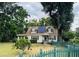 House exterior with solar panels, green fence, and mature trees at 14303 14Th St, Dade City, FL 33523