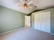 Spacious bedroom with ceiling fan, carpet, and large closet at 16861 Le Clare Shores Dr, Tampa, FL 33624