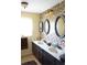 Bathroom featuring a double sink vanity with mosaic tile wall and decorative lighting at 1727 Coco Palm Cir, Sun City Center, FL 33573