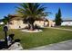 Front yard view of a charming house with a palm tree and manicured lawn at 1727 Coco Palm Cir, Sun City Center, FL 33573
