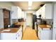 Galley style kitchen with white cabinets, laminate counters, and plank flooring at 1727 Coco Palm Cir, Sun City Center, FL 33573