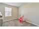 Charming bedroom with a window, carpeted floor, and a baby activity center at 18843 Ulmus St, Lutz, FL 33558