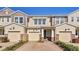 Three-unit townhome building with two-car garages and attractive landscaping at 18843 Ulmus St, Lutz, FL 33558