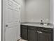 Convenient laundry room with granite countertop and dark cabinets at 18843 Ulmus St, Lutz, FL 33558