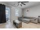 Living room with tile floor, gray sectional sofa and sliding doors leading to a patio at 18843 Ulmus St, Lutz, FL 33558