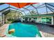 Enclosed pool with patio furniture and a floating burger at 2261 Hidden Meadows E Dr, Palm Harbor, FL 34683