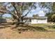 Ranch-style home with a spacious backyard, large tree, and wood fence at 2746 Hibiscus St, Sarasota, FL 34239