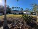 Landscaped yard with a one-story home featuring a gray exterior and a two-car garage at 3087 Seth Rd, North Port, FL 34288
