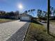 Home's exterior showcases a paved driveway leading to a two-car garage and a spacious yard at 3087 Seth Rd, North Port, FL 34288
