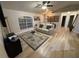 Living room boasts light wood-look flooring, a white couch, and a large TV at 3087 Seth Rd, North Port, FL 34288