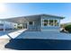 Light blue single-wide manufactured home with carport and landscaped yard at 37832 Mission Hills Ave, Zephyrhills, FL 33541